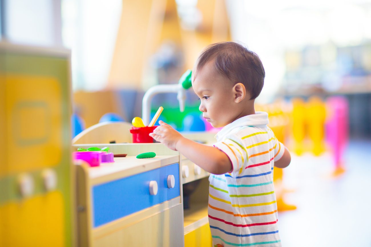 Toddler playing at the toy kitchen